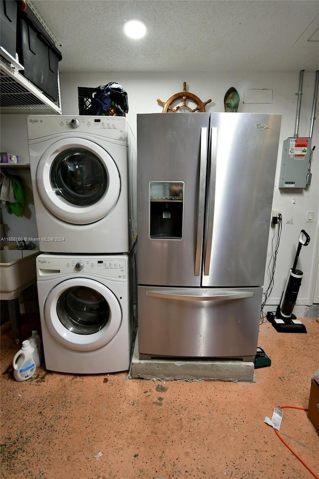 laundry room with a textured ceiling, stacked washing maching and dryer, recessed lighting, and electric panel