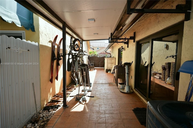 view of patio featuring cooling unit, fence, and a gate