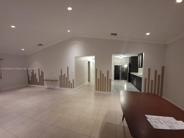 spare room with vaulted ceiling and light tile patterned flooring