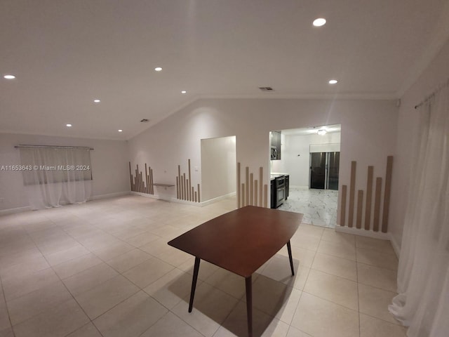 spare room featuring lofted ceiling and light tile patterned floors