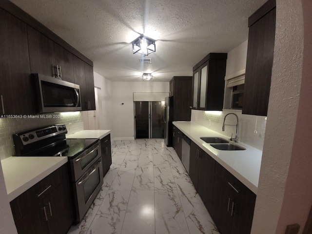 kitchen with stainless steel appliances, a textured ceiling, tasteful backsplash, and sink