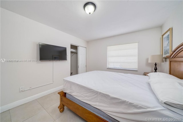 bedroom featuring light tile patterned floors and a closet