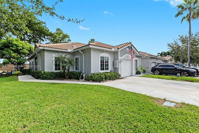 mediterranean / spanish house featuring a front lawn and a garage