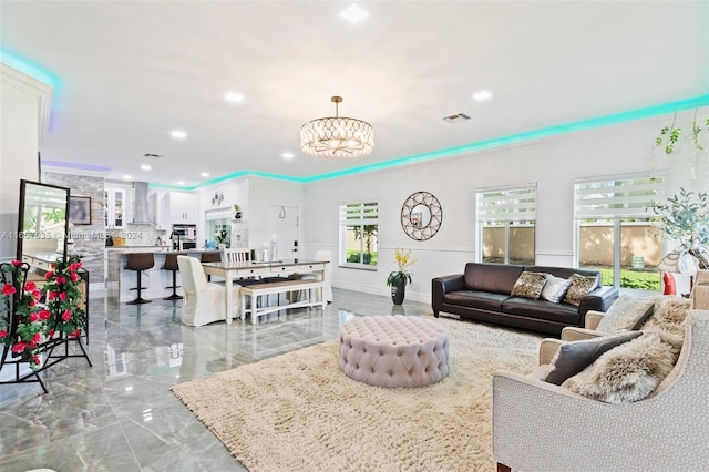 living room featuring a notable chandelier and ornamental molding