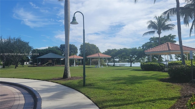 surrounding community with a gazebo, a yard, and a water view