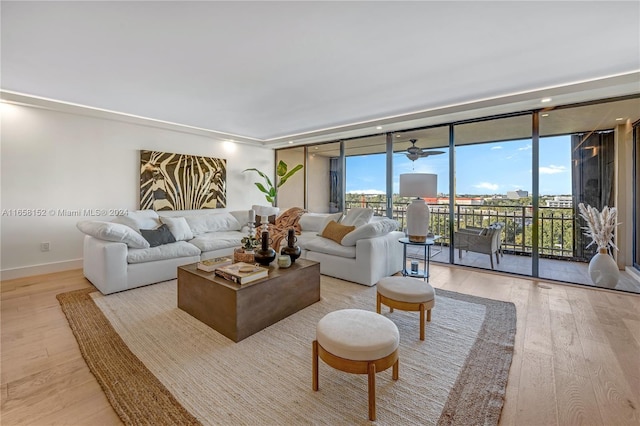 living room with expansive windows and light hardwood / wood-style flooring