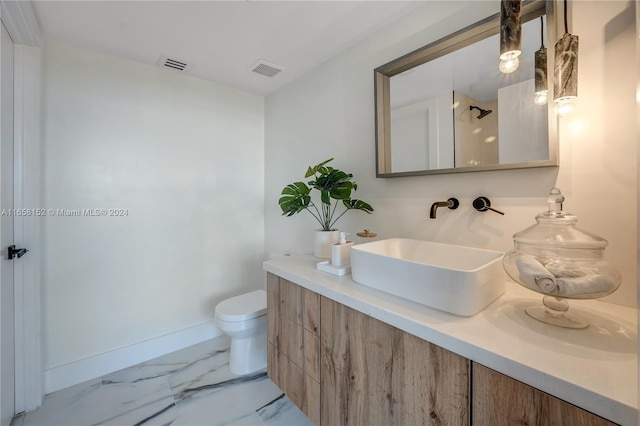 bathroom featuring toilet, vanity, and a shower