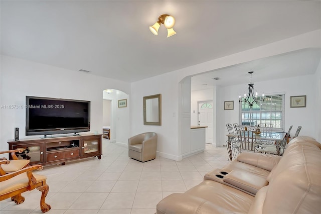 tiled living room with a notable chandelier