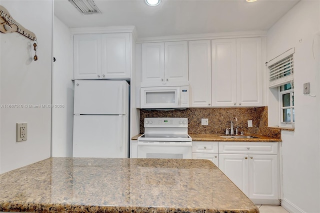 kitchen with light stone countertops, sink, white cabinets, and white appliances