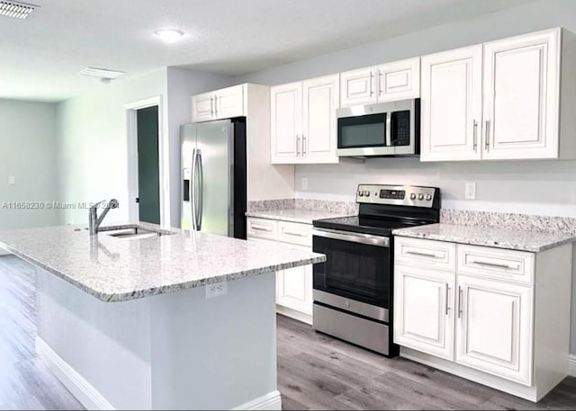 kitchen featuring appliances with stainless steel finishes, white cabinetry, and hardwood / wood-style floors