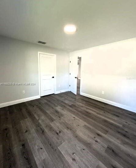 unfurnished room featuring dark wood-type flooring