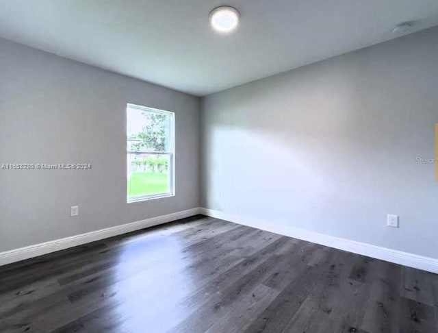 empty room with dark hardwood / wood-style flooring