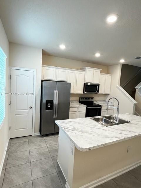 kitchen with sink, stainless steel appliances, white cabinets, and a kitchen island