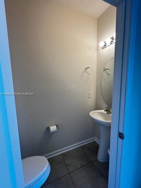 bathroom with toilet and tile patterned flooring