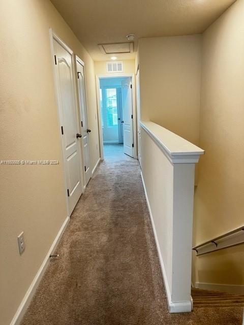 hallway featuring dark carpet