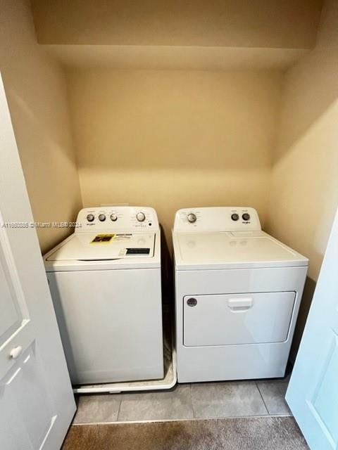 laundry room featuring independent washer and dryer and light tile patterned flooring