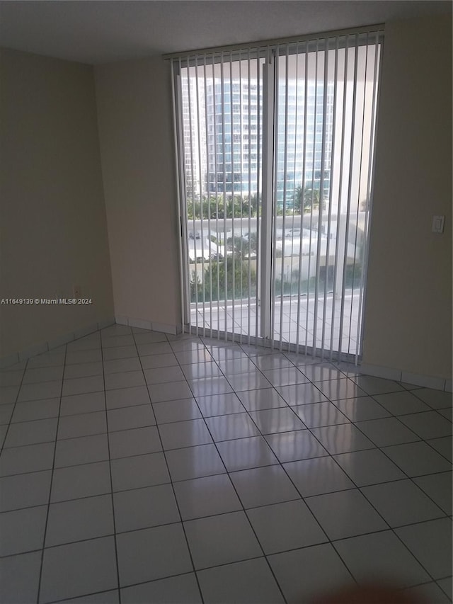 spare room featuring a healthy amount of sunlight and tile patterned floors