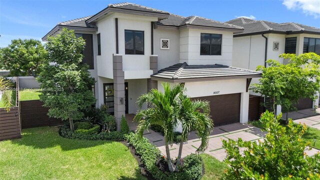 view of front of house featuring a garage and a front lawn