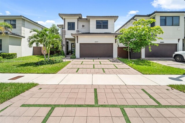 view of front of property with a garage and a front lawn