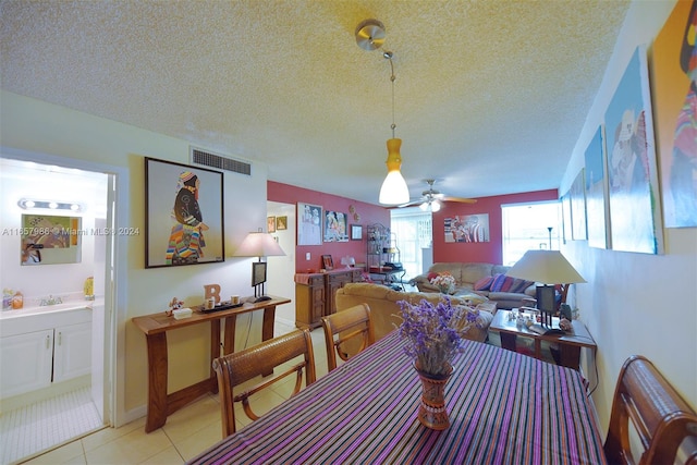 dining room featuring a textured ceiling, ceiling fan, sink, and light tile patterned floors