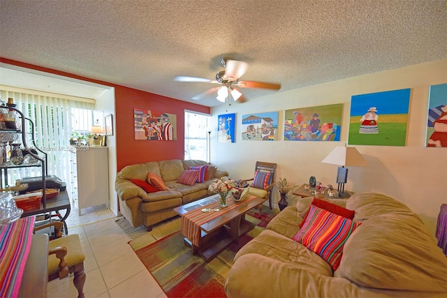 living room featuring ceiling fan, light tile patterned floors, and a textured ceiling