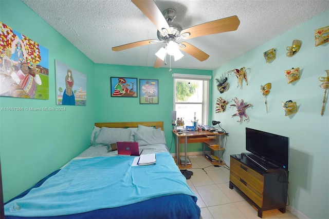 bedroom featuring a textured ceiling, light tile patterned floors, and ceiling fan