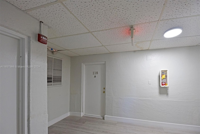 spare room featuring a paneled ceiling and hardwood / wood-style flooring