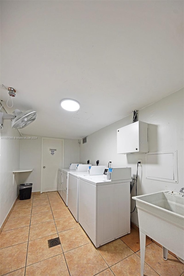 washroom featuring light tile patterned floors, sink, and washing machine and dryer