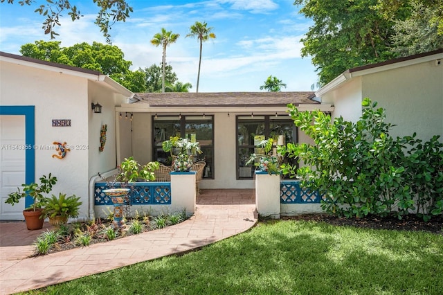 view of exterior entry with a yard