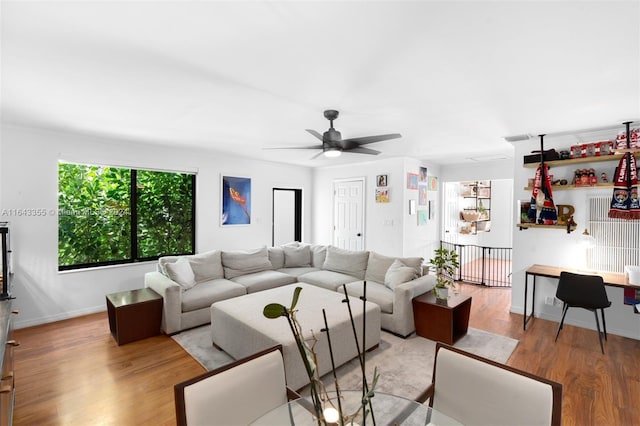 living room featuring light hardwood / wood-style flooring and ceiling fan