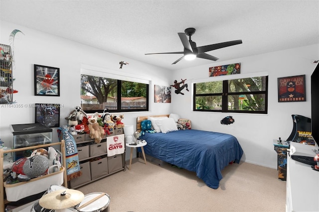 bedroom featuring a textured ceiling, ceiling fan, and carpet floors