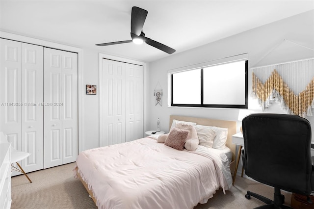 carpeted bedroom featuring multiple closets and ceiling fan