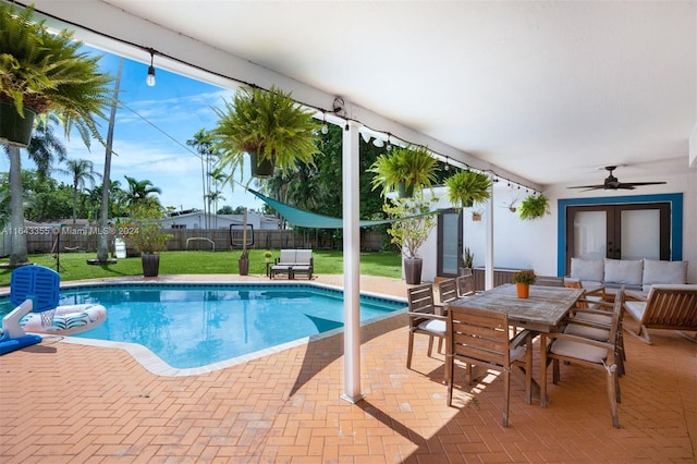 view of swimming pool with a yard, ceiling fan, and a patio