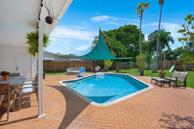 view of pool with a lawn and a patio area