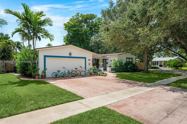 single story home featuring a garage and a front lawn