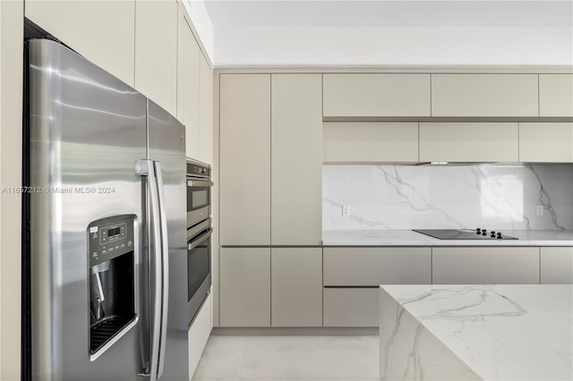 kitchen with light stone countertops, stainless steel appliances, and backsplash