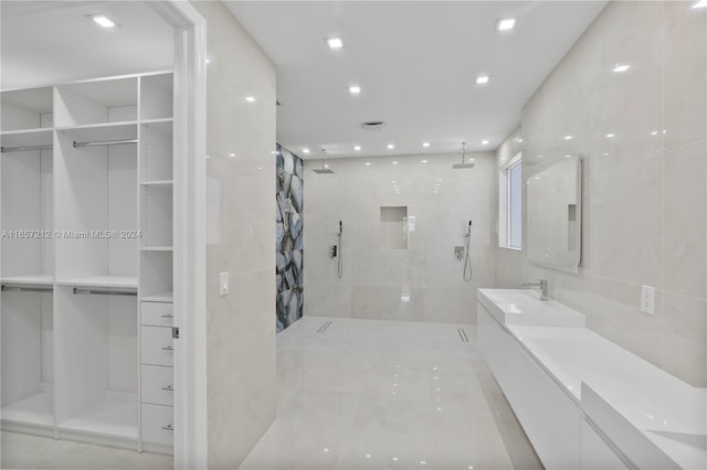 bathroom with vanity, tile walls, and a tile shower