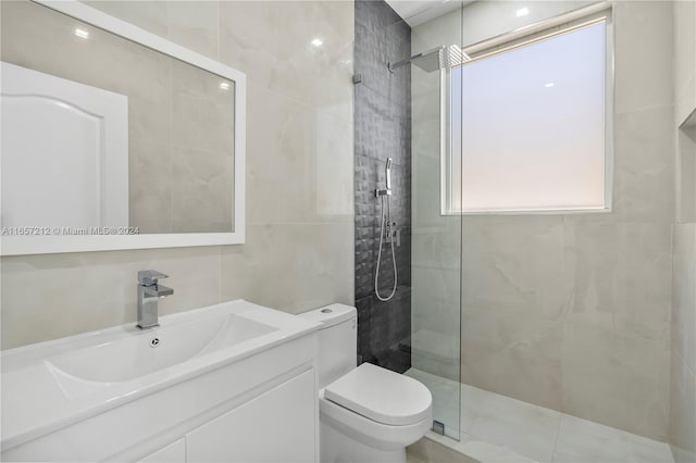 bathroom with vanity, toilet, tile walls, and tiled shower