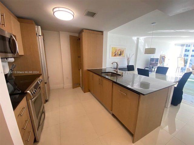 kitchen featuring dark stone countertops, pendant lighting, light tile patterned floors, and sink