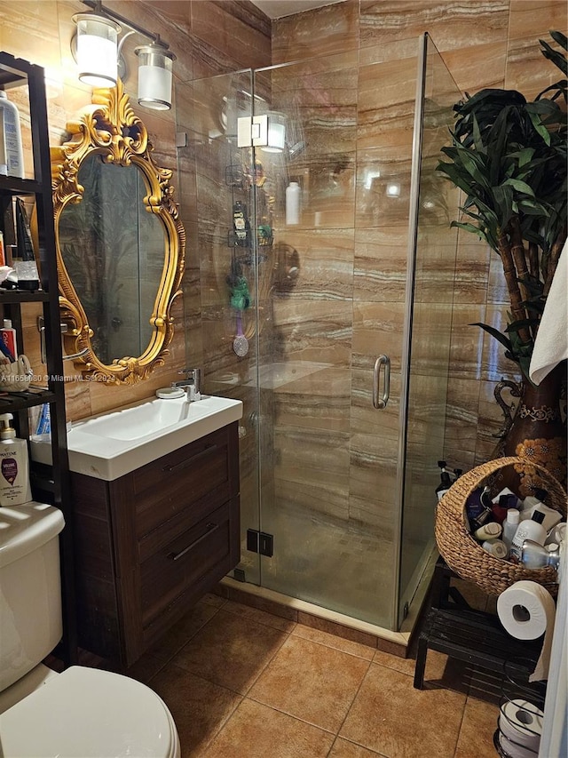 bathroom featuring vanity, toilet, a shower with shower door, and tile patterned flooring