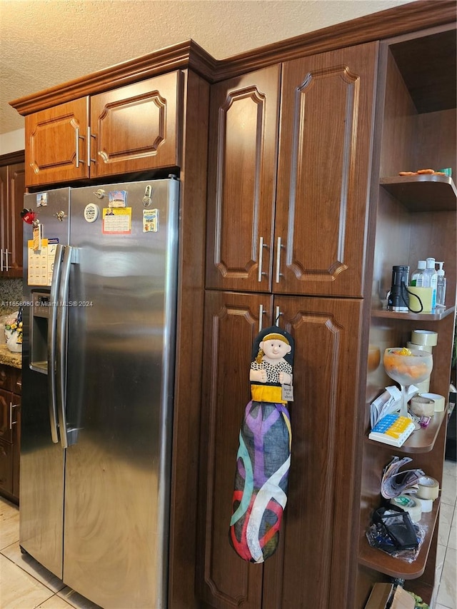 kitchen featuring light tile patterned floors, stainless steel fridge with ice dispenser, and stone counters