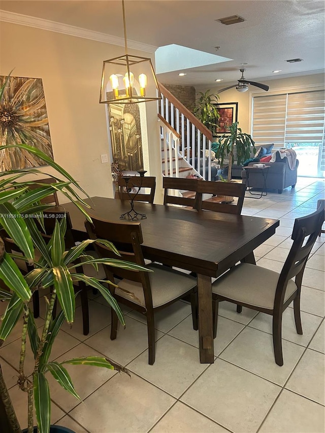 tiled dining area with ceiling fan with notable chandelier and crown molding