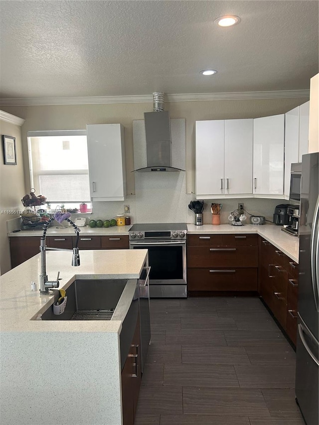 kitchen with dark wood-type flooring, sink, white cabinetry, wall chimney range hood, and appliances with stainless steel finishes