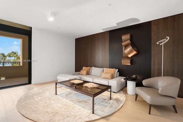 living room with wooden walls and light hardwood / wood-style floors