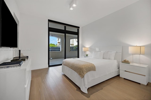 bedroom featuring floor to ceiling windows, access to exterior, and light hardwood / wood-style flooring