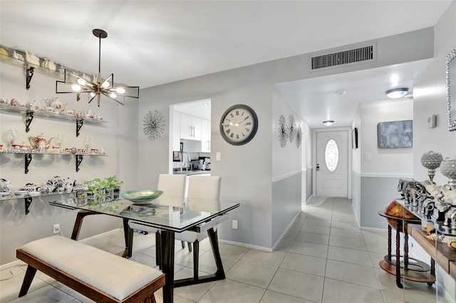 dining space with a notable chandelier, light tile patterned flooring, and sink