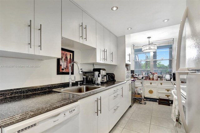 kitchen with white cabinets, hanging light fixtures, white dishwasher, and sink