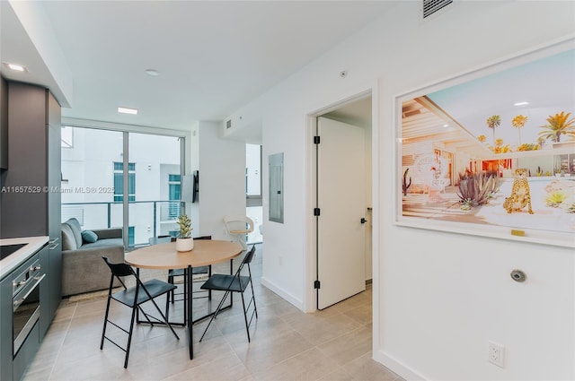 dining space featuring expansive windows, light tile patterned floors, and electric panel