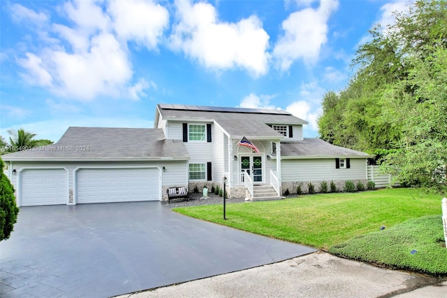 view of front of home with a garage, a front lawn, and solar panels