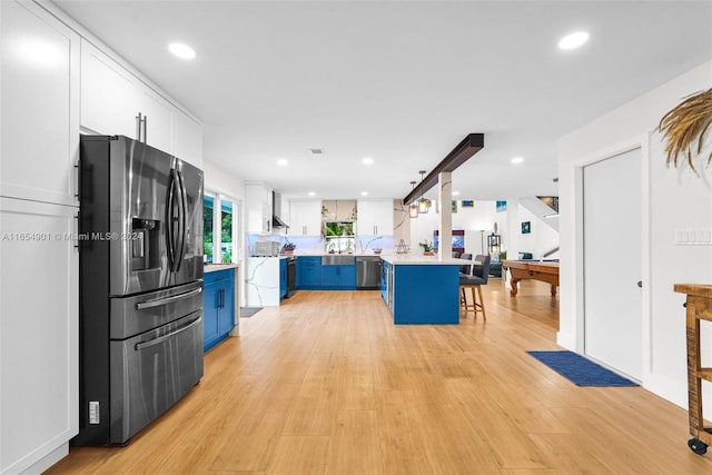 kitchen featuring billiards, blue cabinetry, a breakfast bar, appliances with stainless steel finishes, and white cabinets